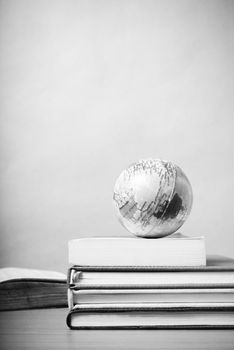 book and earth ball on wood background black and white color tone style