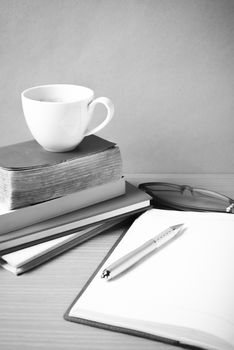 open book with coffee cup on wood background black and white color tone style