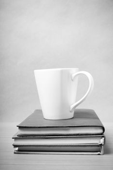 stack of book with coffee mug on wood background black and white tone style