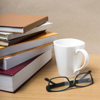 stack of book with coffee mug on wood background