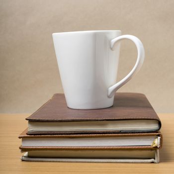 stack of book with coffee mug on wood background