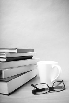 stack of book with coffee mug on wood background black and white tone style