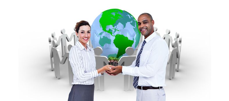 Business colleagues holding plant and looking at camera against human figures surround earth