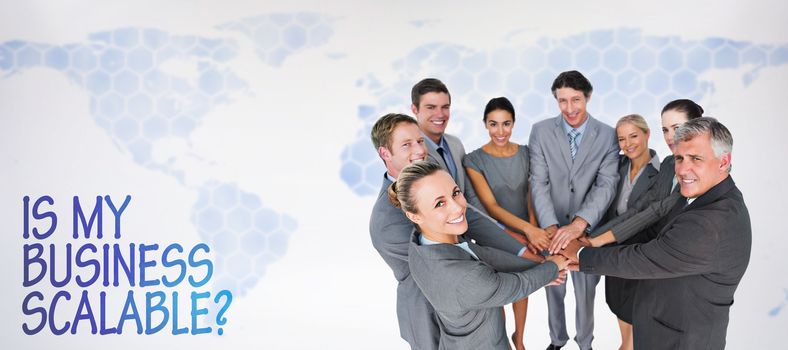Smiling business team standing in circle hands together against background with world map