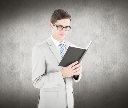Geeky businessman reading black book against white and grey background