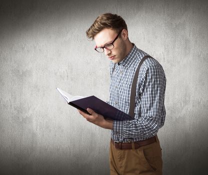 Geeky student reading a book against white and grey background