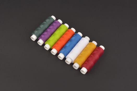 colorful spools thread on dark background