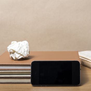 stack of book with smart phone on wood background