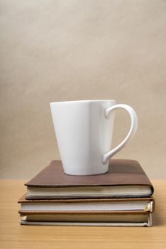 stack of book with coffee mug on wood background