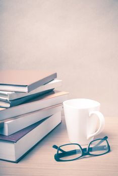 stack of book with coffee mug on wood background vintage style
