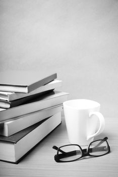 stack of book with coffee mug on wood background black and white tone style