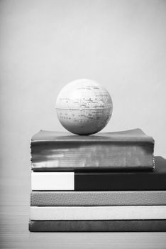 book and earth ball on wood background black and white color tone style