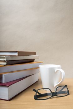 stack of book with coffee mug on wood background