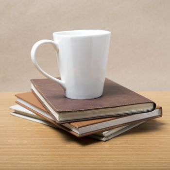 stack of book with coffee mug on wood background