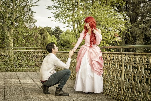 Romantic Fairy Tale Couple in Beautiful Palace Garden in Peaceful Idyllic Setting, Man is Proposing to Woman, Prince and Princess Gazing at Each Other