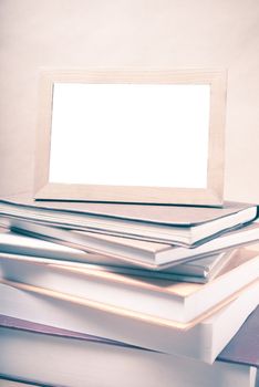 stack of book and photo frame on wood background vintage style