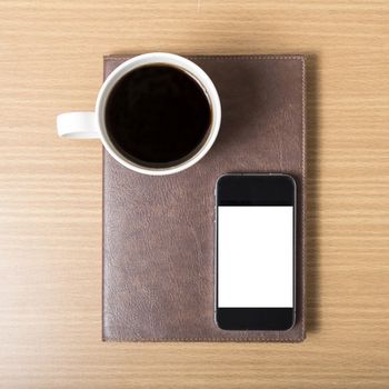 smart phone and coffee cup on book on wood background