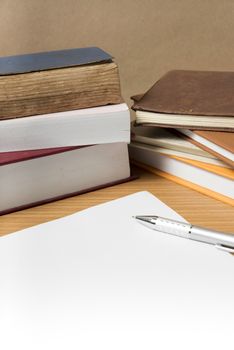 empty paper and pen with book on wood background