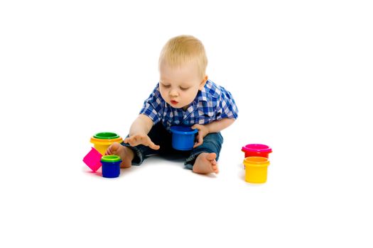 baby boy sitting on a white floor with toys