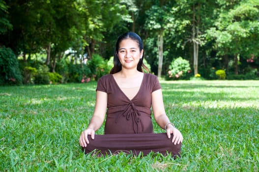 Pregnant woman sitting in the park . in anticipation of the child. Senses of tenderness, love and motherhood. toned photo