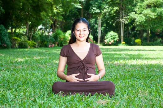 Pregnant woman sitting in the park . in anticipation of the child. Senses of tenderness, love and motherhood. toned photo