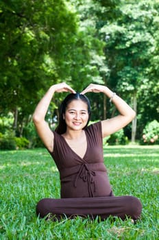 Pregnant woman sitting in the park . in anticipation of the child. Senses of tenderness, love and motherhood. toned photo