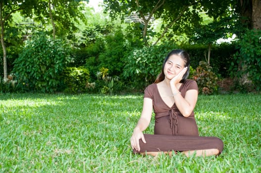 Pregnant woman sitting in the park . in anticipation of the child. Senses of tenderness, love and motherhood. toned photo