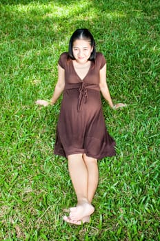 Pregnant woman sitting in the park . in anticipation of the child. Senses of tenderness, love and motherhood. toned photo