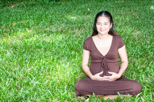 Pregnant woman sitting in the park . in anticipation of the child. Senses of tenderness, love and motherhood. toned photo