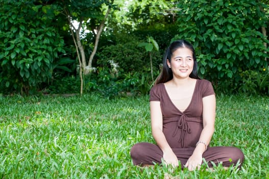 Pregnant woman sitting in the park . in anticipation of the child. Senses of tenderness, love and motherhood. toned photo