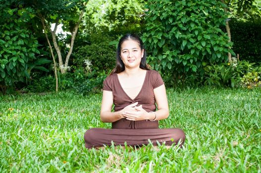 Pregnant woman sitting in the park . in anticipation of the child. Senses of tenderness, love and motherhood. toned photo