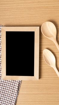 blackboard and wooden spoon on table