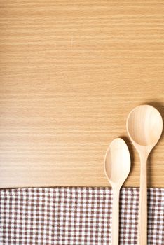 wood spoon and kitchen towel on table