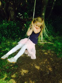 Girl swinging from a tree