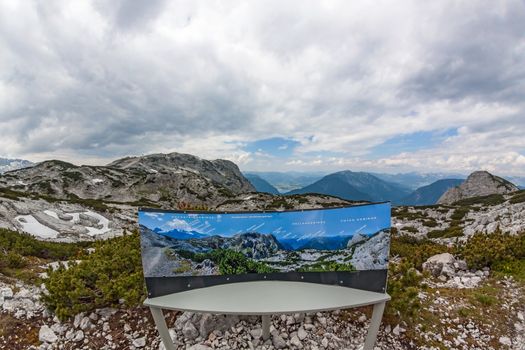 Obertraun, Austria - June 27, 2014: Dachstein Mountains 180 degree panorama shot with information sign at the Dachstein Shark.