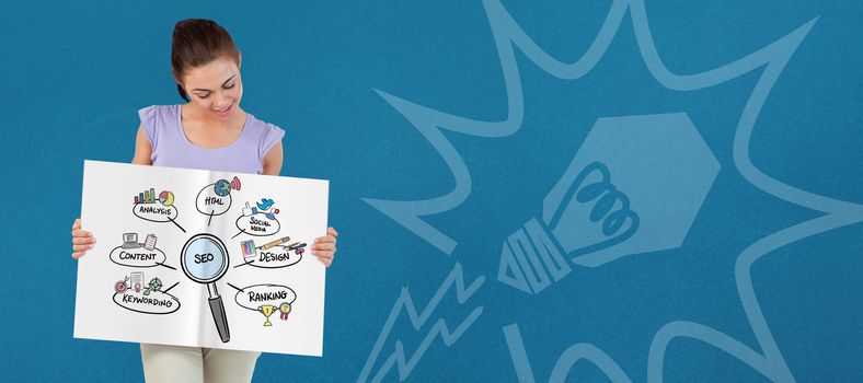 Pretty girl showing a book against blue background