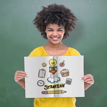 Pretty girl showing a book against green chalkboard