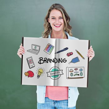 Pretty woman showing a book against green chalkboard