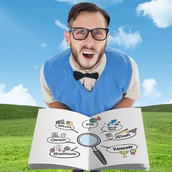 Nerd showing a book against blue sky over green field