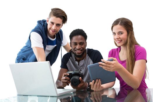 Creative young business team looking at digital tablet against white background with vignette