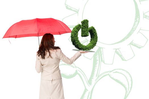 Woman with umbrella and lawn book against on sign made of leaves