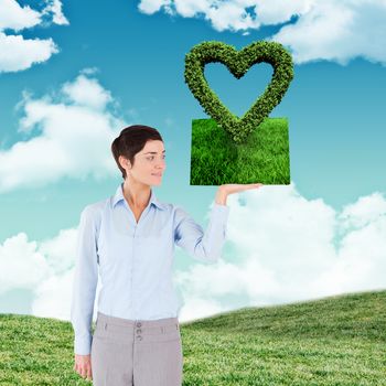 Woman holding lawn book against blue sky over green field