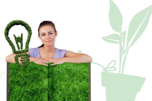 Woman with lawn book against light bulb made of leaves