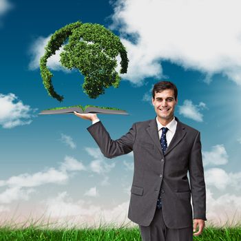 Man holding up lawn book against green field under blue sky