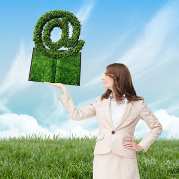 Woman holding lawn book  against blue sky over green field