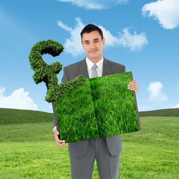 Man holding lawn book against blue sky over green field