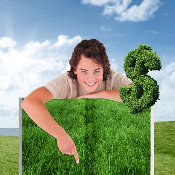 Person pointing against green field under blue sky