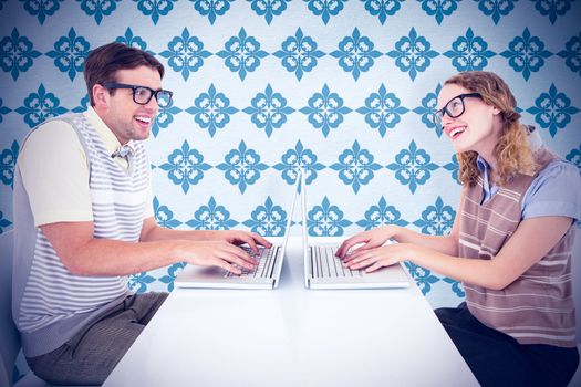 Geeky hipster couple using laptop against blue background