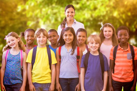 Cute pupils smiling at camera in the hall  against trees and meadow in the park