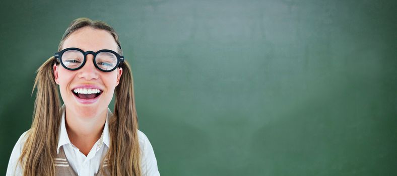 Female geeky hipster smiling at camera against green chalkboard